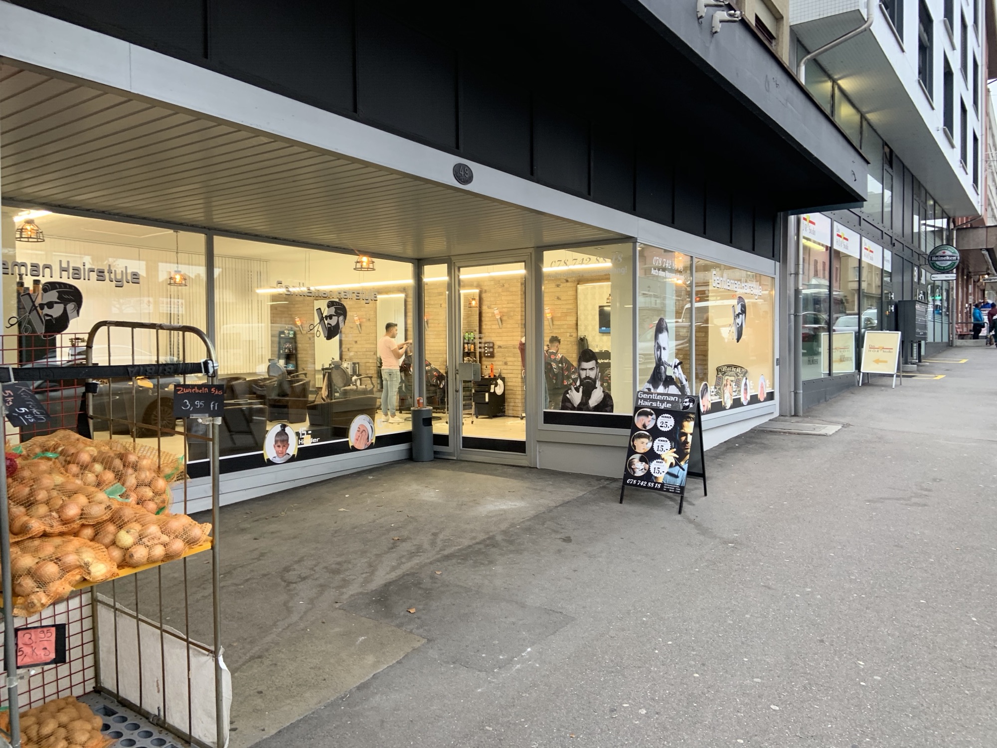 Ladenfront von Gentleman Hairstyle an der Gerliswilstrasse, beleuchtete Schaufenster